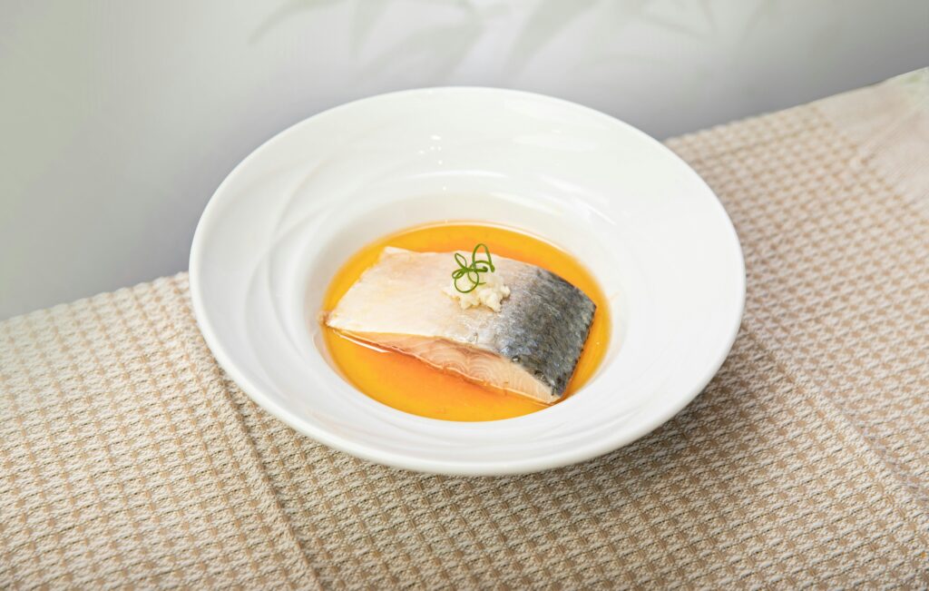 Delicious salmon served in a vibrant orange sauce with garnish.